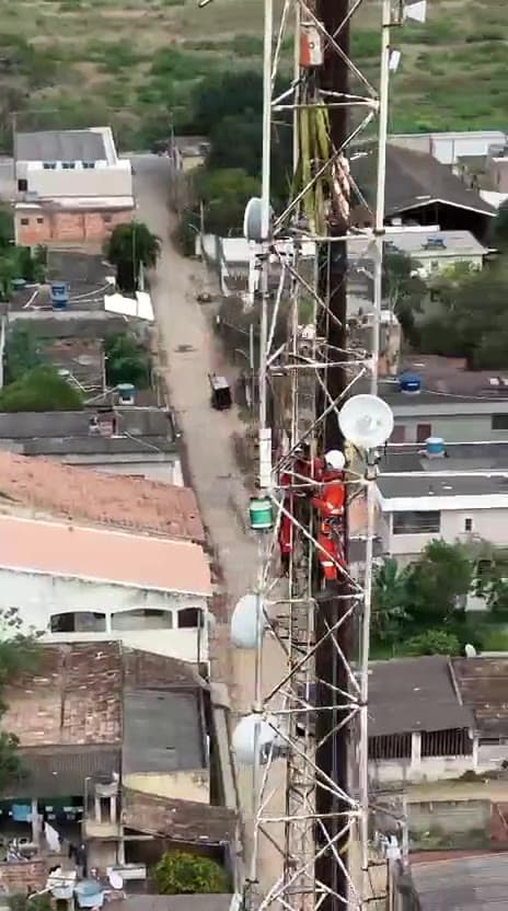 Técnico em acesso por cordas realizando manutenção em torre