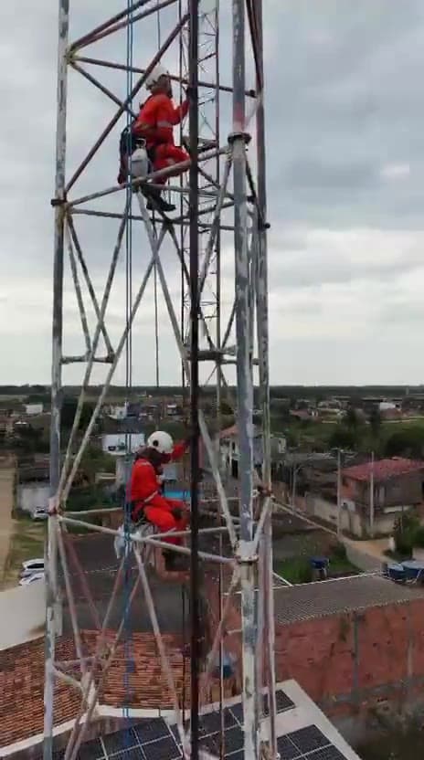 Dois técnicos em acesso por cordas no topo da torre