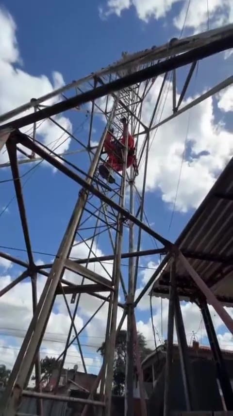 Técnico subindo estrutura metálica da torre