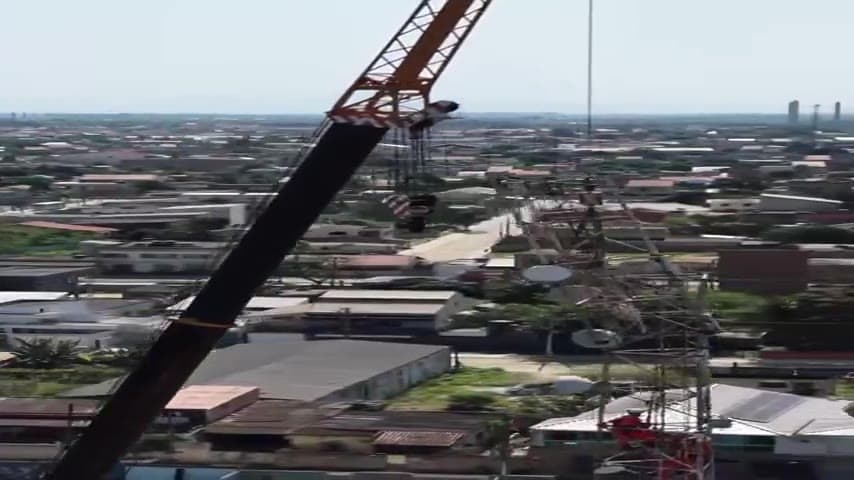 Guindaste operando sobre estrutura em telhado